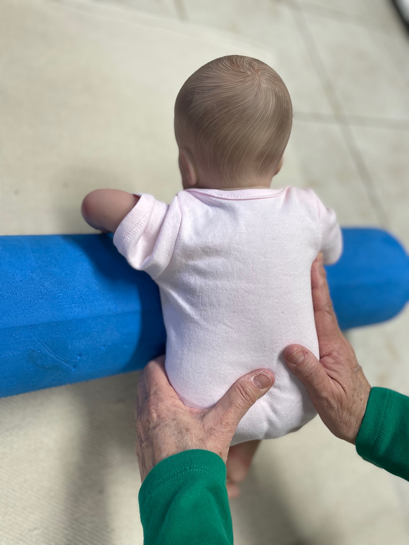 Baby practicing head support with caregiver guidance